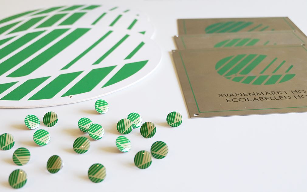 Pins, väggskyltar och mobiler med Svanenmärket på