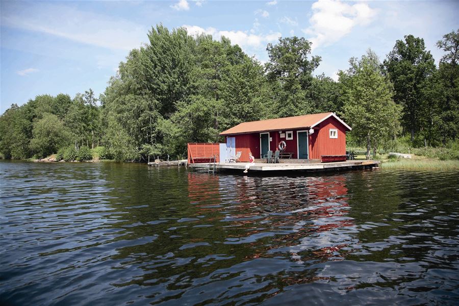 Röd badstuga eller fiskebod på brygga sommartid