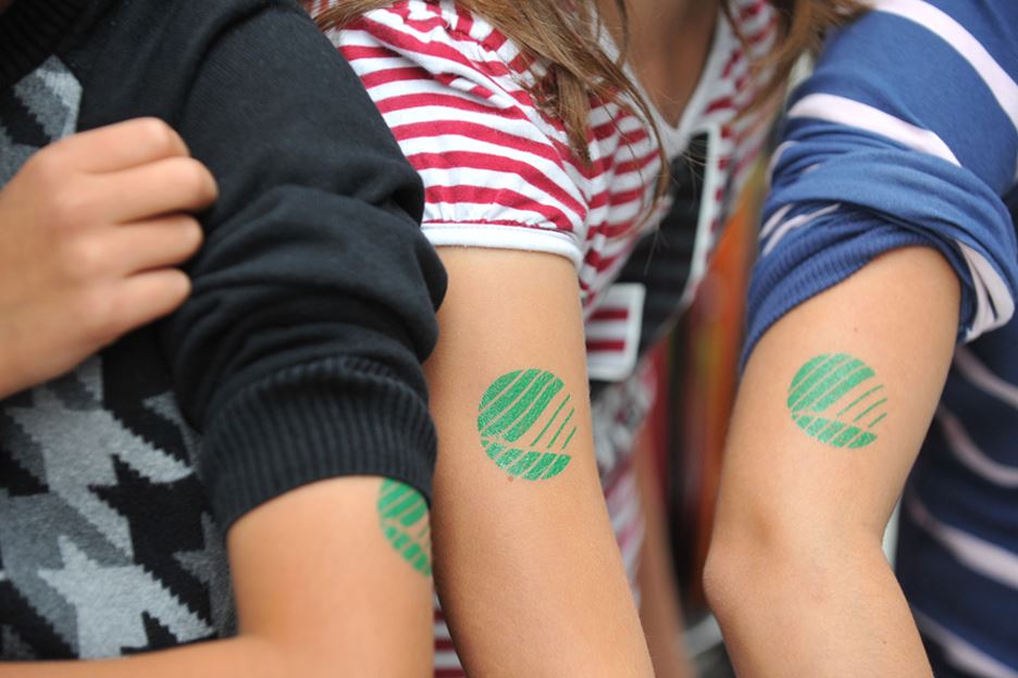 Bild på tre armar med Svanenmärket tatuerade