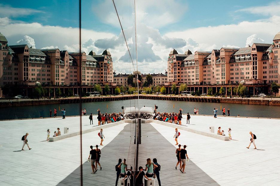 Byggnad med spegelfasad som reflekterar staden och människor