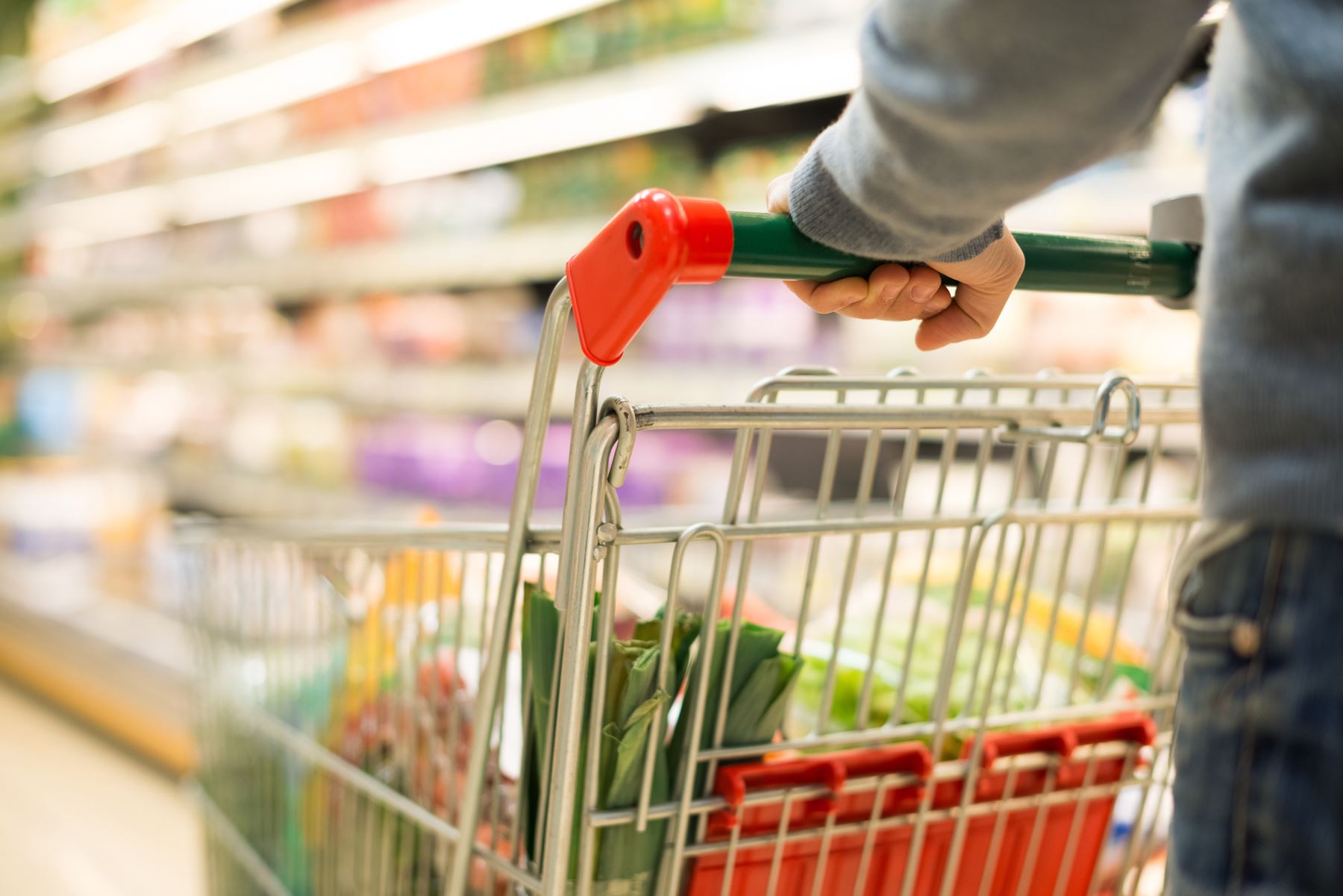 En kundvagn fylld med mat som dras i en dagligvarubutik