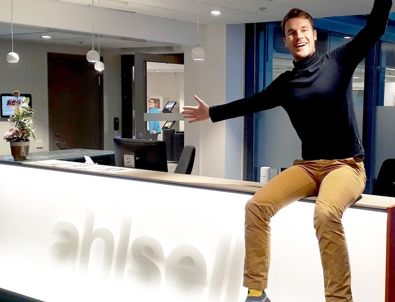 En asap student som sitter på en bänkskiva som det står ahlsell på
