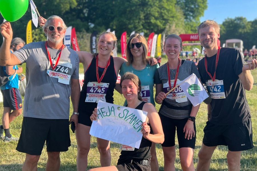 Medarbetare på Svanen som sprungit blodomloppet, håller om varandra och ler