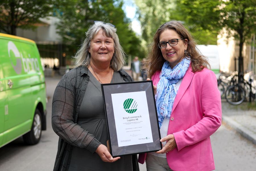 Catherine Löfquist, hållbarhetschef på Bring och Anna Linusson, vd på Svanen håller i ett Svanencertifikat som Bring precis fått.