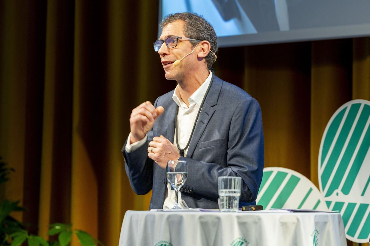 Svanens vd Anna Linusson och Mathias Krümmel, vd Postnord Sverige står framför en PostNord-bil och håller i ett certifigat för Svanenmärkning av e-handelstransporter.